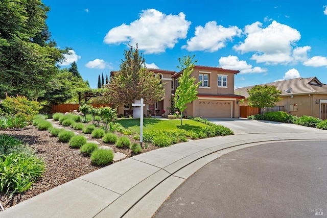 view of front of property featuring an attached garage, fence, driveway, and stucco siding