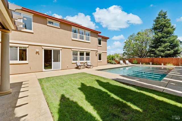 rear view of house with a patio, a fenced backyard, stucco siding, a fenced in pool, and a yard