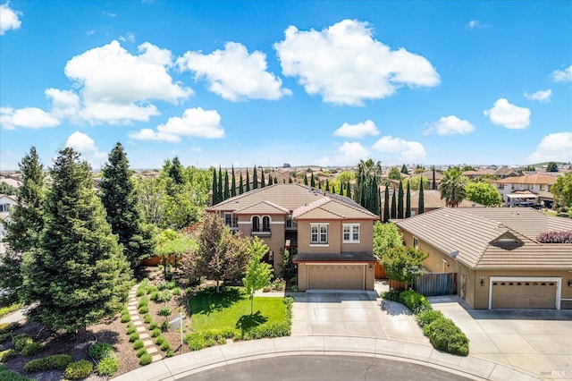 traditional-style house with a residential view, stucco siding, a tile roof, and concrete driveway