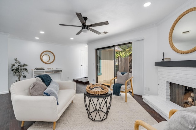 living area featuring visible vents, ornamental molding, a brick fireplace, ceiling fan, and recessed lighting