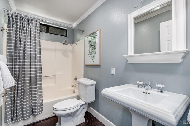 bathroom with wood finished floors, shower / tub combo, a sink, toilet, and ornamental molding