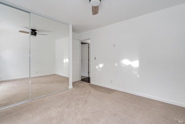 unfurnished bedroom featuring carpet floors, baseboards, ceiling fan, and a closet