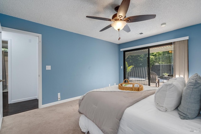 bedroom featuring a textured ceiling, visible vents, carpet floors, baseboards, and access to outside