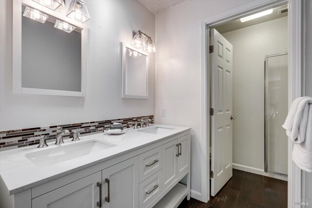 bathroom featuring a sink, backsplash, and wood finished floors