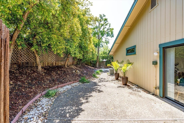 view of side of home with fence and a patio area