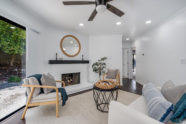 living room featuring crown molding, recessed lighting, a ceiling fan, and a fireplace