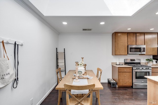 kitchen with brown cabinets, stainless steel appliances, dark wood-type flooring, visible vents, and ornamental molding