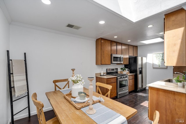 kitchen featuring a sink, crown molding, stainless steel appliances, and recessed lighting