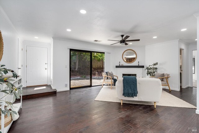 living area featuring a ceiling fan, baseboards, visible vents, and ornamental molding