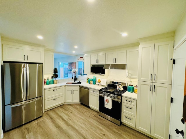 19 4th St, Richmond, CA 94801 - kitchen with stainless steel appliances, under cabinet range hood, a sink, white cabinets, and recessed lighting