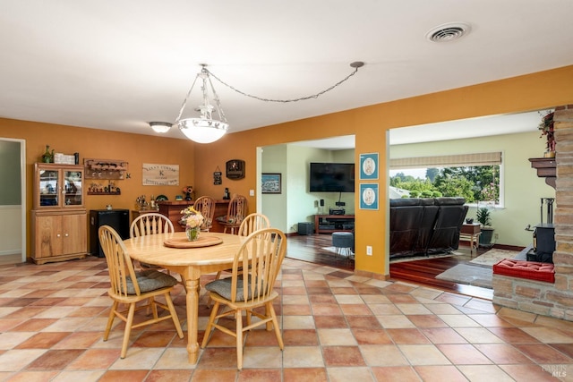 dining area featuring visible vents and a wood stove