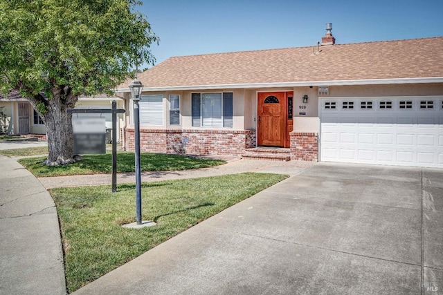 ranch-style home featuring roof with shingles, a garage, brick siding, a front lawn, and concrete driveway