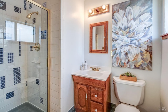 bathroom featuring vanity, toilet, and a shower stall