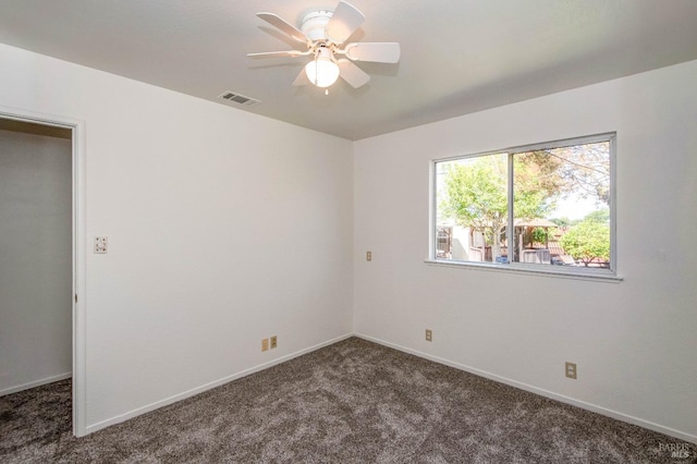 unfurnished room featuring carpet floors, ceiling fan, visible vents, and baseboards