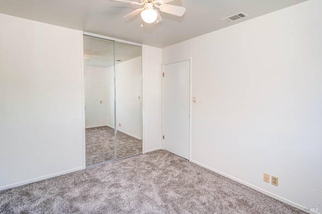 unfurnished bedroom featuring ceiling fan, visible vents, baseboards, a closet, and carpet flooring