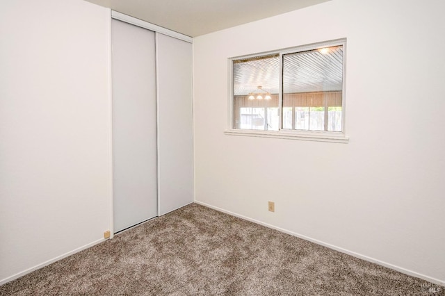 unfurnished bedroom with a closet, carpet flooring, and baseboards