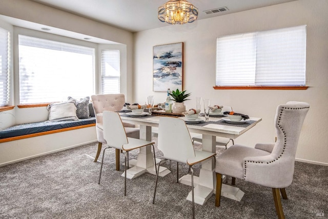 carpeted dining space with baseboards, visible vents, and a notable chandelier