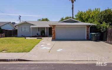 ranch-style house featuring a garage, fence, a front yard, and concrete driveway