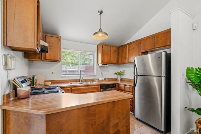 kitchen with appliances with stainless steel finishes, a sink, brown cabinetry, a peninsula, and lofted ceiling