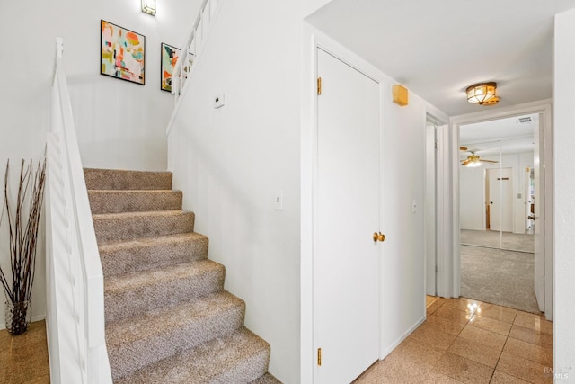 stairway with visible vents, ceiling fan, and granite finish floor