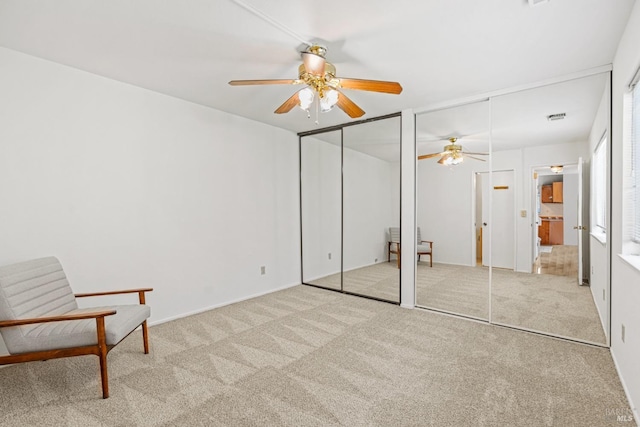 unfurnished bedroom featuring carpet flooring, a ceiling fan, and two closets