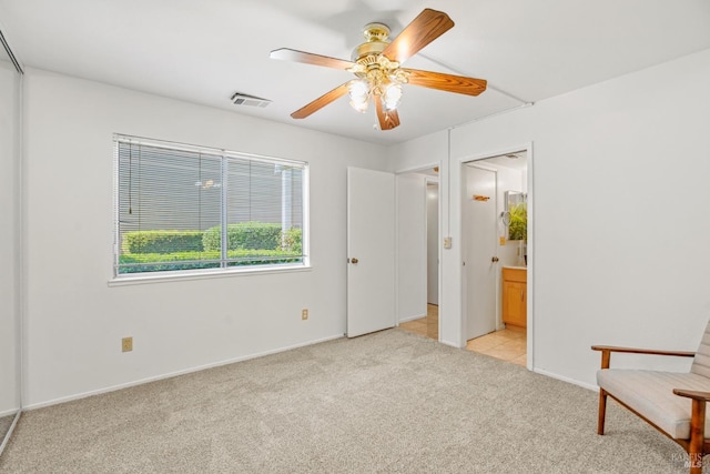 interior space featuring visible vents, baseboards, ceiling fan, and light colored carpet