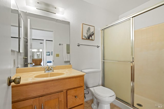 full bath with a shower stall, tile patterned floors, vanity, toilet, and ensuite bathroom