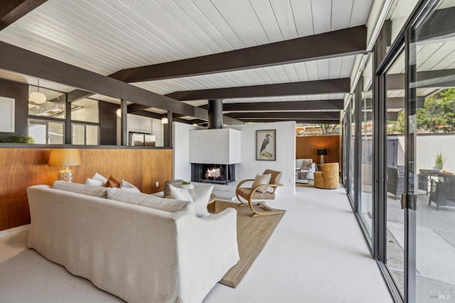 living room with beam ceiling, healthy amount of natural light, and a multi sided fireplace