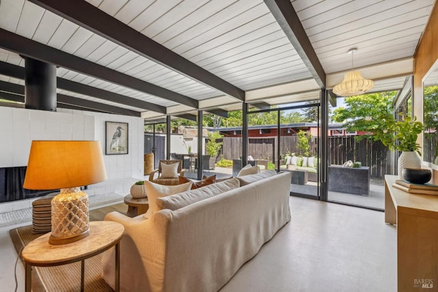 living area with floor to ceiling windows, beam ceiling, and healthy amount of natural light