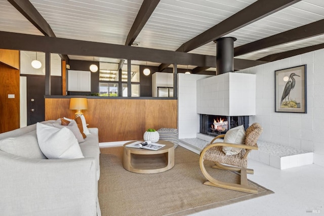 living room with beam ceiling and a tiled fireplace