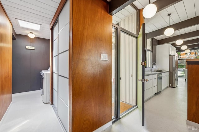 corridor with beamed ceiling and a sink