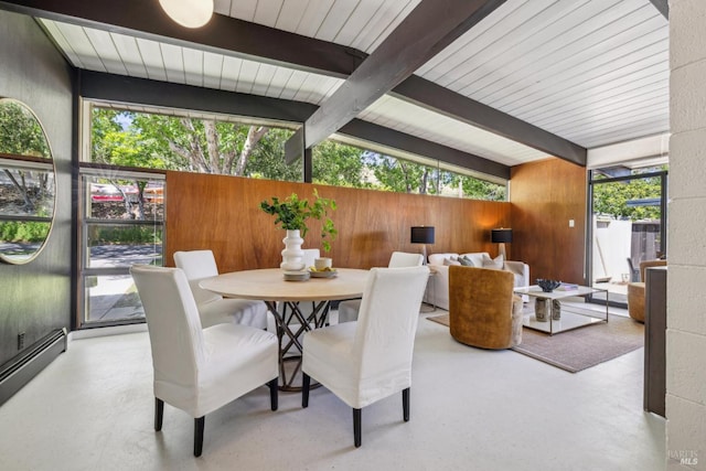 dining area with wood walls and baseboard heating