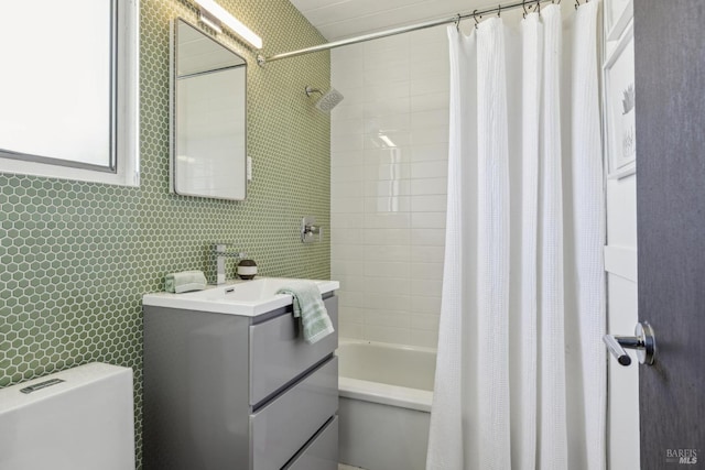 bathroom featuring tile walls, shower / tub combo with curtain, toilet, and vanity