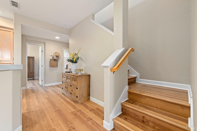 stairs with baseboards, recessed lighting, wood finished floors, and visible vents