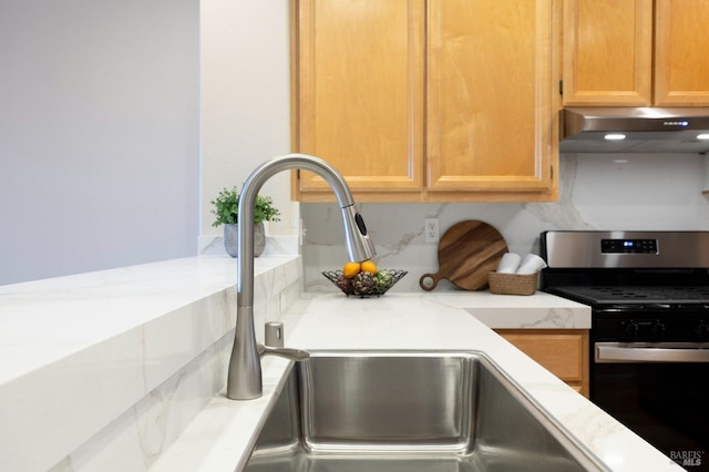 interior details with under cabinet range hood and stainless steel gas range