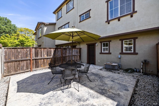 view of patio featuring fence, central AC unit, and outdoor dining space
