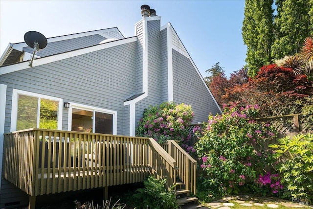 rear view of property featuring a wooden deck and a chimney
