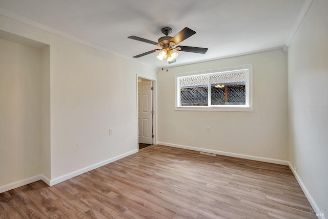 empty room with crown molding, baseboards, ceiling fan, and light wood-type flooring