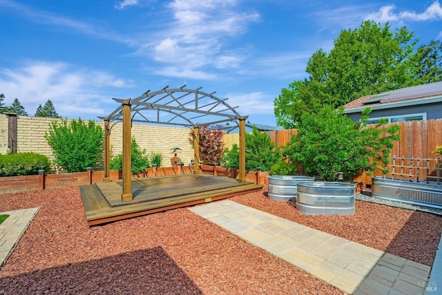 exterior space with a fenced backyard, a pergola, a deck, and a vegetable garden