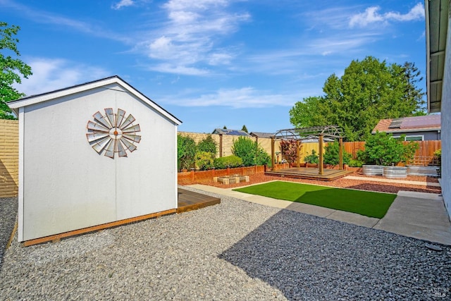 view of yard with a fenced backyard, an outbuilding, a garden, and a shed