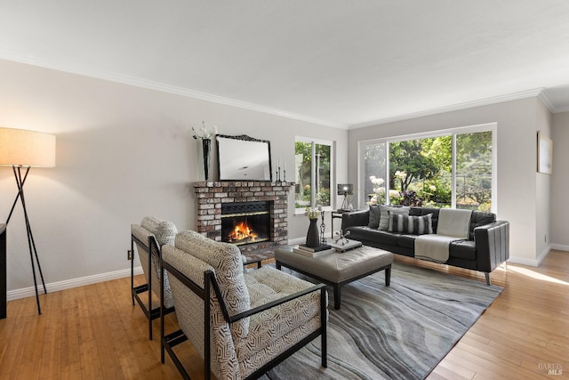 living area featuring baseboards, ornamental molding, a fireplace, and light wood finished floors