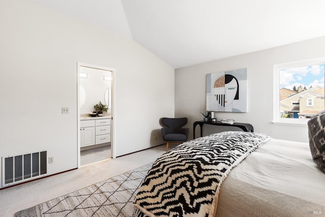 bedroom featuring visible vents, light carpet, ensuite bathroom, and lofted ceiling