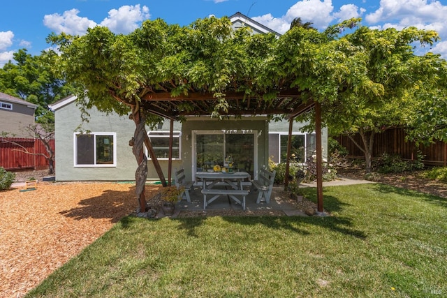 rear view of house with a fenced backyard, a patio, stucco siding, and a yard