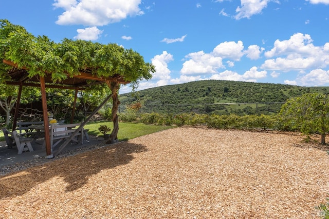 view of yard with a patio area, a mountain view, and fence