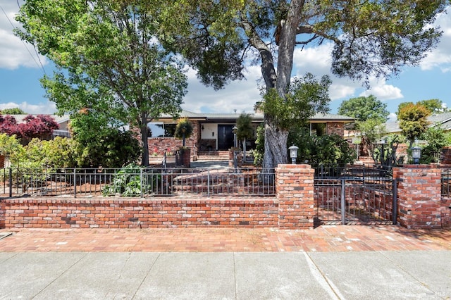 view of front of property featuring a fenced front yard and brick siding