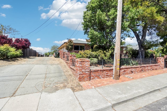 view of front of property with fence and aphalt driveway
