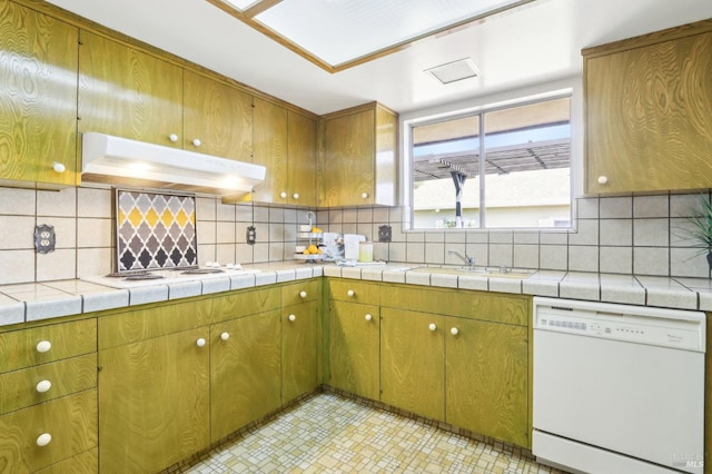kitchen featuring a sink, tasteful backsplash, under cabinet range hood, and white appliances