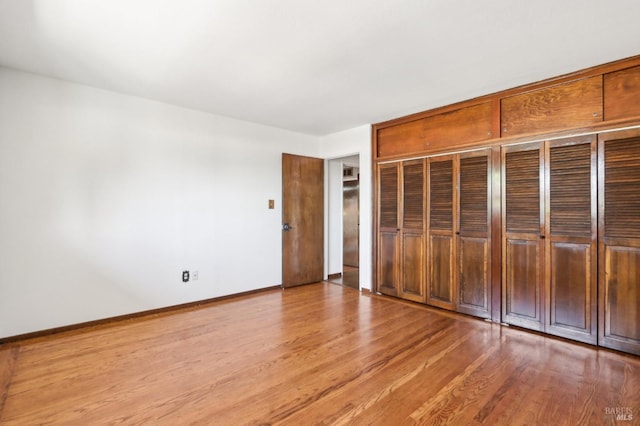 unfurnished bedroom with baseboards and wood finished floors