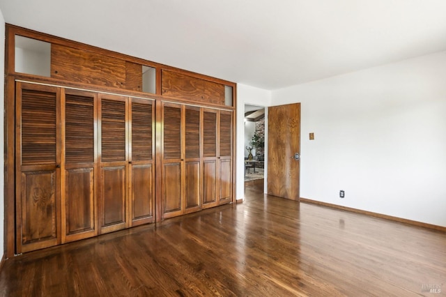 interior space featuring baseboards, dark wood-style floors, and a closet