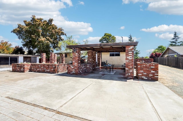 rear view of property with fence, a patio, and stucco siding